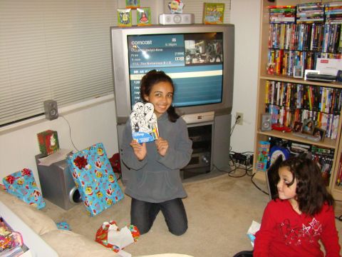 1989 Ford Bronco - A holiday scene with two girls, wrapped gifts, and a television displaying a Comcast channel guide.