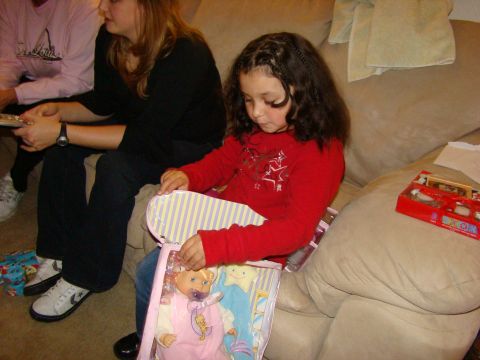 1989 Ford Bronco - A young girl unwraps a doll while sitting on a couch with family during what appears to be a holiday gathering.