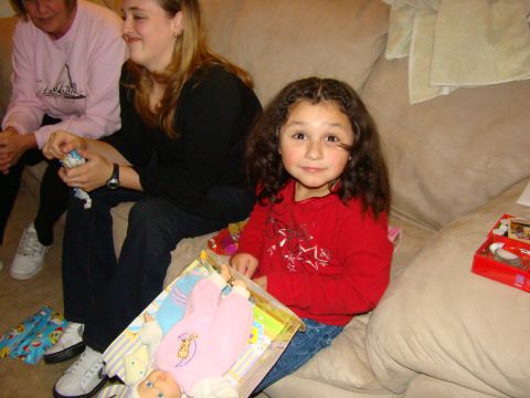 1989 Ford Bronco - A young girl receives a doll as a gift while sitting with two women on a couch.