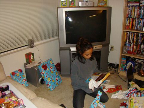1989 Ford Bronco - A young girl sits on the floor opening Christmas presents in front of a large television set.