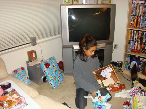 1989 Ford Bronco - A girl unwraps gifts in a room filled with holiday decorations and entertainment systems.