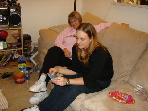 1989 Ford Bronco - A casual indoor scene shows two women relaxing on a sofa, with a shelf of items in the background.