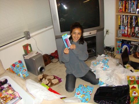 1989 Ford Bronco - A young girl holds up a new item while sitting amongst presents and a large television.