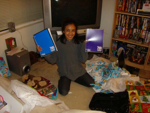 1989 Ford Bronco - A girl kneels amidst wrapping paper and gifts, holding two notebooks.