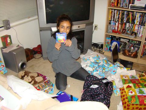 1989 Ford Bronco - A young woman holds up a pack of erasers while surrounded by Christmas gifts and wrapping paper.