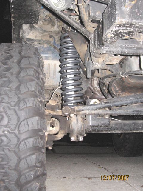 1994 Ford Bronco - Front suspension coil spring and tire detail.