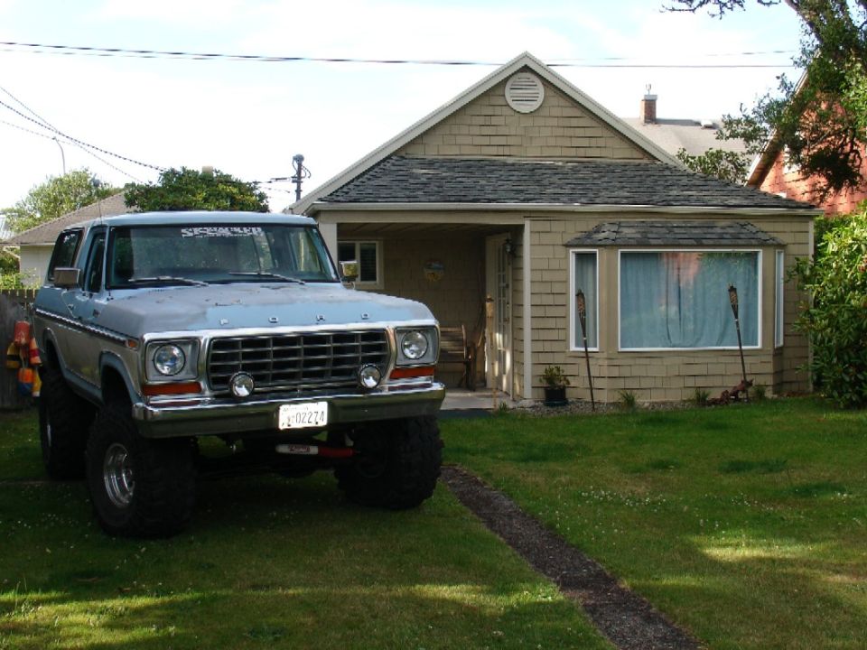1978 Ford Bronco parked in front of a house, lifted with large tires
