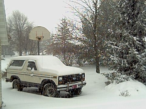 1986 Ford Bronco - A 1986 Ford Bronco sits covered in snow during a winter storm.