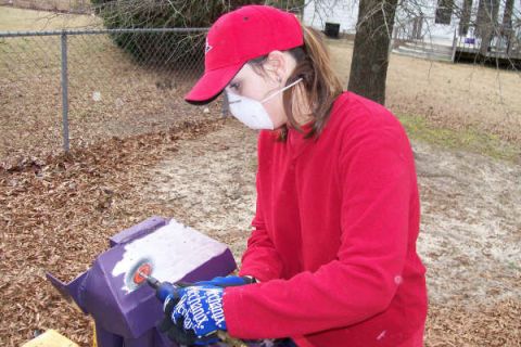 1988 Ford Bronco - Person wearing a mask and gloves works on a purple object outdoors.
