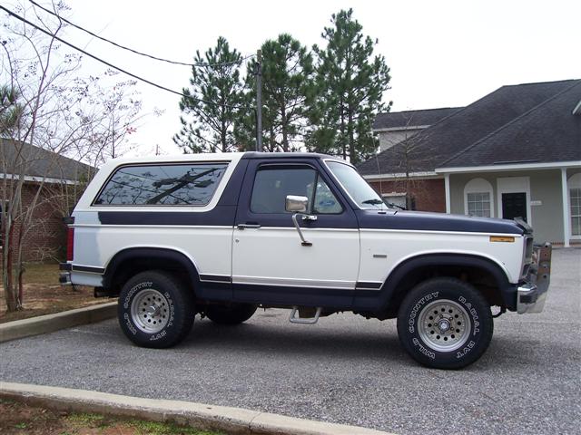Ford Bronco, two-tone white and blue, parked in gravel lot
