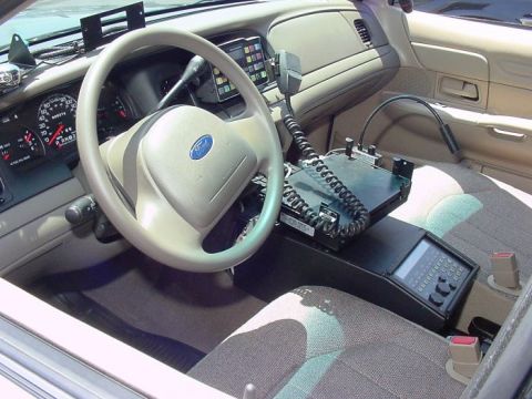 2001 Ford Crown Victoria - The interior of a 2001 Ford Crown Victoria, equipped with a police radio and console, is shown.