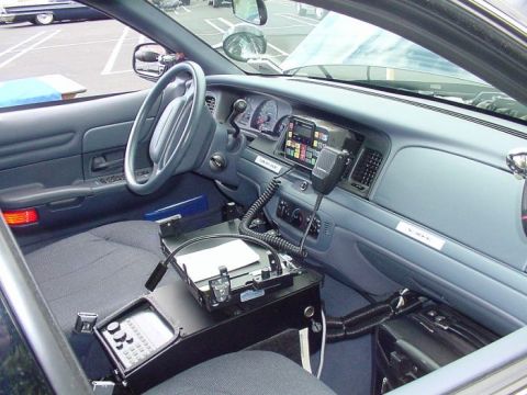 2001 Ford Crown Victoria - The interior of a police car is equipped with a radio, computer terminal, and other communication devices.