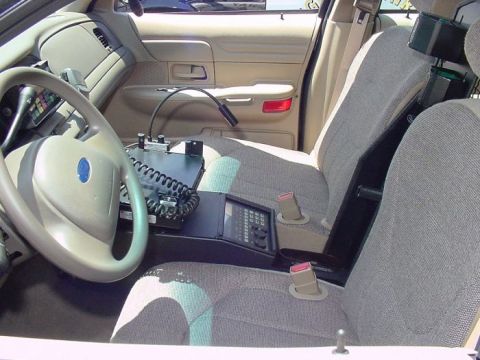 2001 Ford Crown Victoria - The interior of a 2001 Ford Crown Victoria police car is visible, a steering wheel, radio equipment, and seats.
