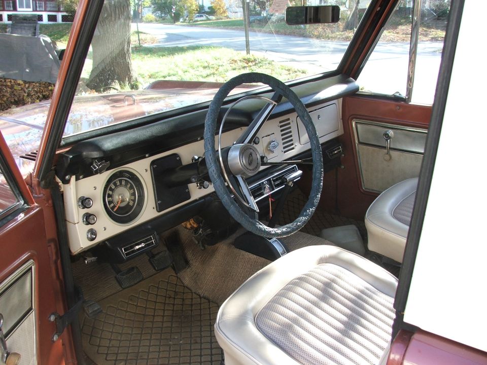 Interior shot of a classic Ford Bronco, showing the dashboard, steering wheel, and seats