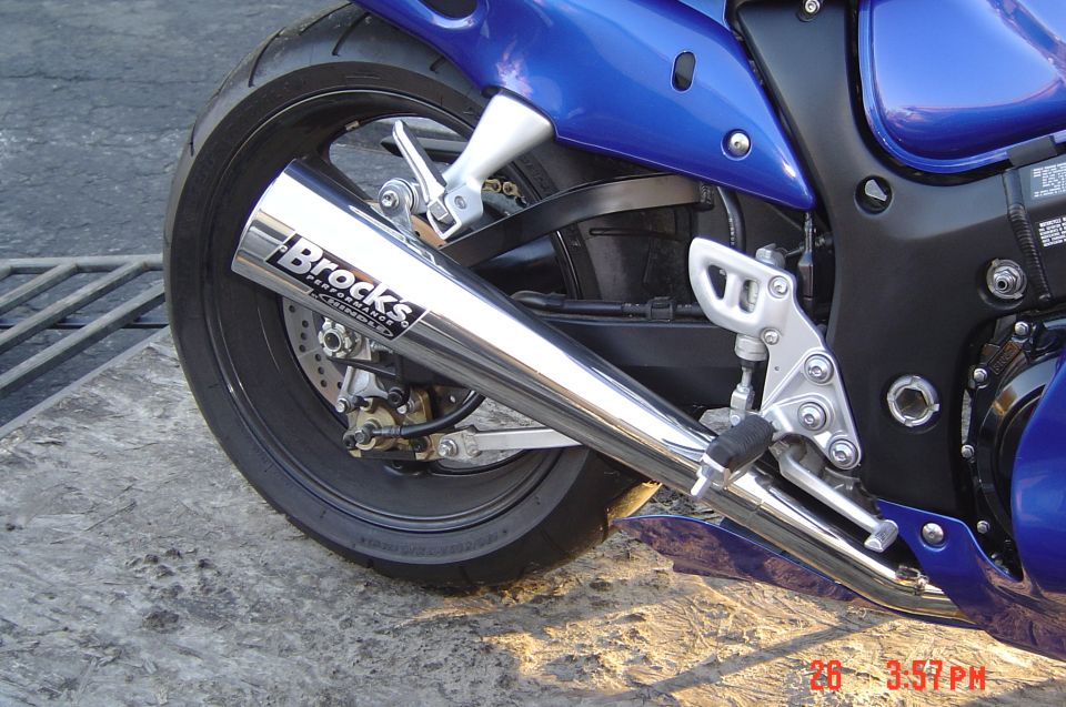 Close-up of a chrome motorcycle exhaust pipe with 'Brocks Performance' logo