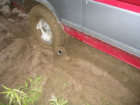 1995 Ford Bronco - Vehicle stuck in mud, showing tire and lower body panel.