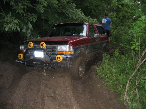 1995 Ford Bronco - This 1995 Ford Bronco is navigating a muddy trail, its KC lights illuminated.