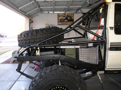 1986 Toyota Hilux - Modified off-road truck with extensive roll cage and external spare tire storage.