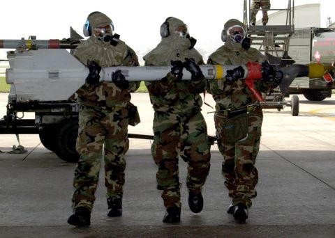 1994 Ford Bronco - Military personnel transport a missile, wearing protective gear and respirators.
