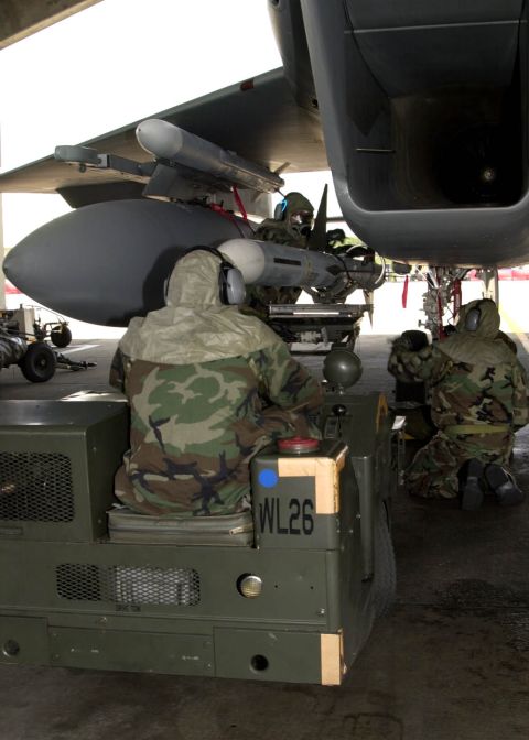 1994 Ford Bronco - Personnel prepare a missile for an aircraft, with a utility vehicle nearby.