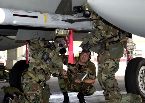 1994 Ford Bronco - Ground crew performs maintenance on an aircraft, checking a missile system.