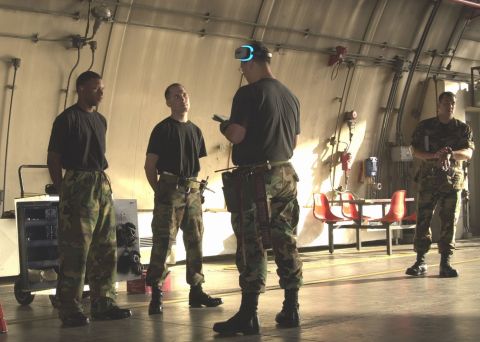 1994 Ford Bronco - Military personnel gather in a large indoor space, possibly a hangar, with one individual using virtual reality equipment.