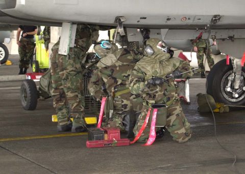 1994 Ford Bronco - Personnel in protective gear are seen working beneath an aircraft on a tarmac, with a "SUPERMOTORS" watermark visible.