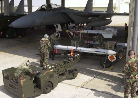 1994 Ford Bronco - Military personnel prepare an F-15 Eagle fighter jet for flight, loading missiles onto the aircraft.