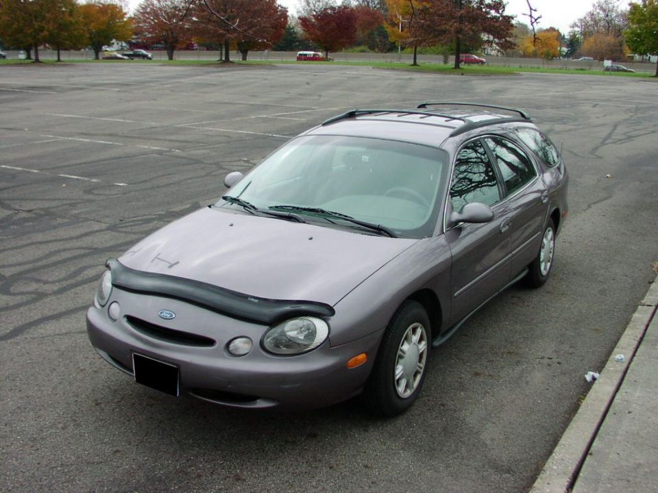 Mauve Ford Taurus station wagon front three-quarter in empty lot with front bra