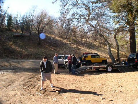 2007 Toyota FJ Cruiser - Several FJ Cruisers and a black SUV are parked in a wooded area, with people standing around.