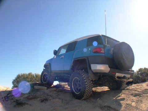 2007 Toyota FJ Cruiser - A blue Toyota FJ Cruiser navigates a rocky off-road trail under a clear blue sky.