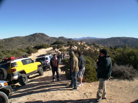 2007 Toyota FJ Cruiser - A group of people stand by their Toyota FJ Cruisers on a dusty trail in a mountainous area.