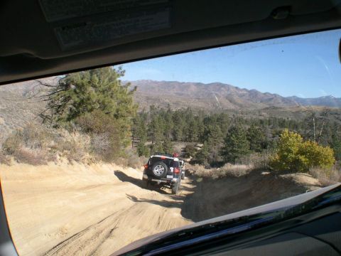 2007 Toyota FJ Cruiser - Two Toyota FJ Cruisers navigate a dusty mountain trail during an off-road excursion.