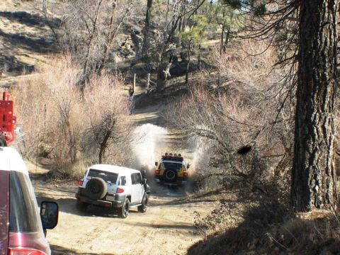 2007 Toyota FJ Cruiser - Two FJ Cruisers splash through water on a dirt road during an off-road excursion.
