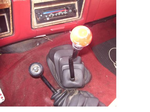 1986 Ford Bronco - Interior view of a 1986 Ford Bronco, highlighting the dual gear shifters and vintage radio unit.