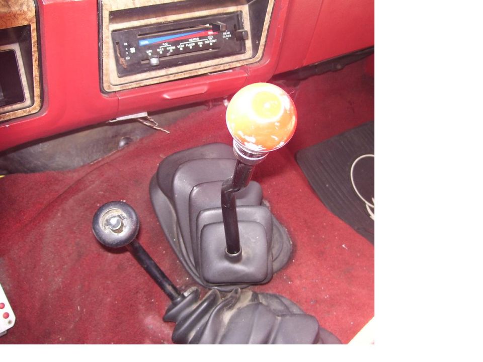 1986 Ford Bronco interior showing two gear shifters and the dashboard radio