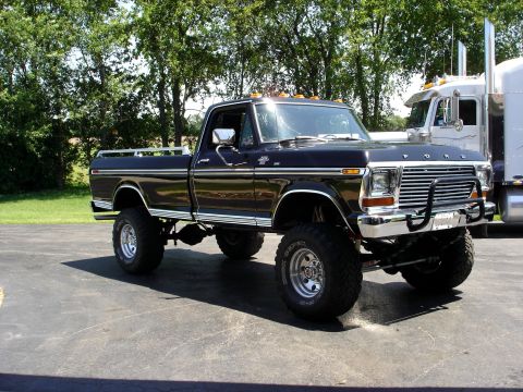 1979 Ford F-250 - A lifted 1979 Ford F-250 pickup truck is parked outdoors next to a semi-truck.
