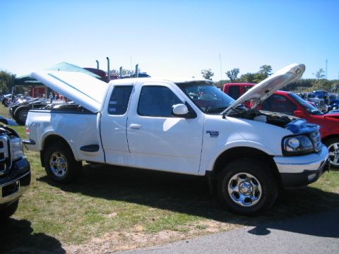 2003 Ford F-150 - White 2003 Ford F-150 pickup truck with hood and tonneau cover open, parked outdoors.
