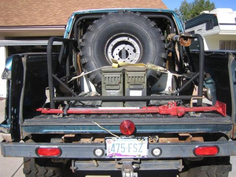 1994 Ford Bronco - The rear of a 1994 Ford Bronco is equipped with a spare tire, ammo cans, and a high-lift jack.