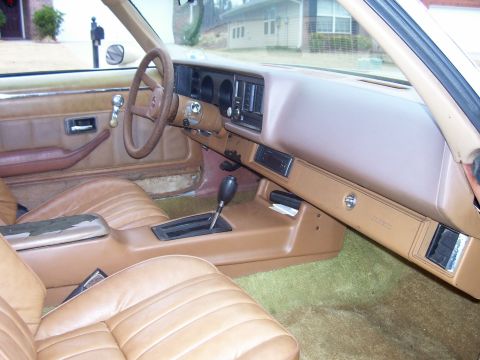 1979 Chevrolet Camaro - The interior of a 1979 Chevrolet Camaro shows tan upholstery, a four-spoke steering wheel, and the center console with an automatic shifter.