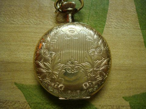 1994 Ford Bronco - A gold pocket watch with intricate floral engravings is shown from the back.