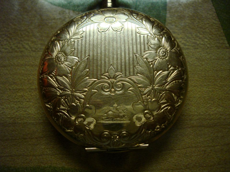 Engraved gold pocket watch with floral motifs and a central landscape scene