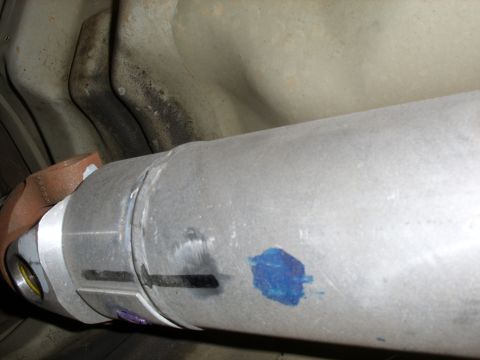 2005 Ford Crown Victoria - Underside view of a driveshaft with a U-joint and blue markings.