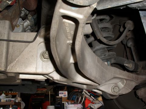 2005 Ford Crown Victoria - Close-up view of the suspension system's control arm and coil spring assembly.