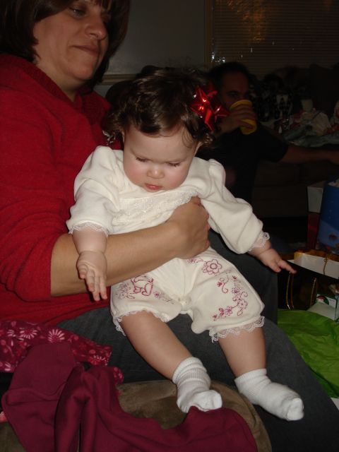 2000 Ford Crown Victoria - A baby sits on someone's lap, dressed in a festive outfit with a red bow in her hair.