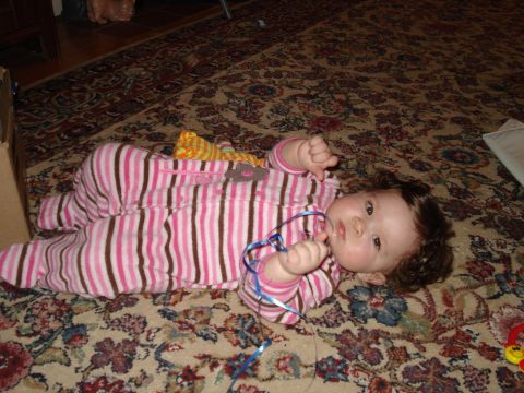 2000 Ford Crown Victoria - A baby lies on a rug, playing with a blue ribbon.