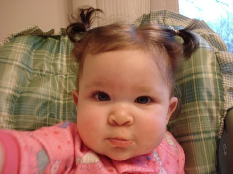2000 Ford Crown Victoria - A baby with pigtails and a serious expression is wearing pink pajamas.