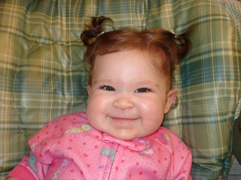 2000 Ford Crown Victoria - Baby with red hair in pigtails smiles while wearing pink pajamas.