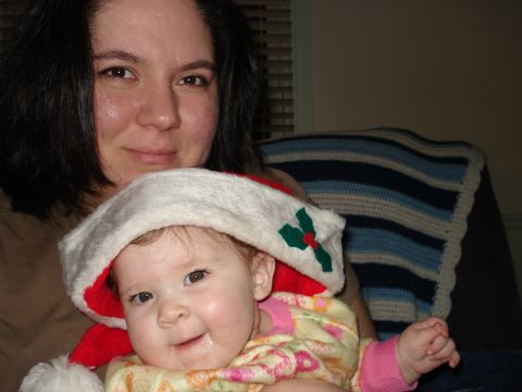 2000 Ford Crown Victoria - A woman holds a baby wearing a festive Santa hat, likely during the holiday season.