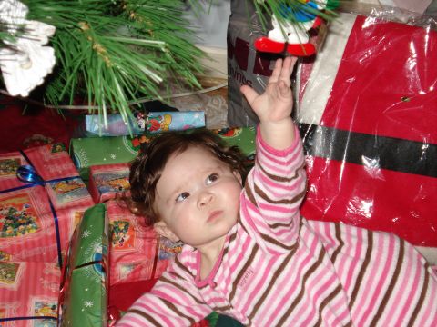 2000 Ford Crown Victoria - A baby reaches for a Christmas ornament while surrounded by gifts under a tree.